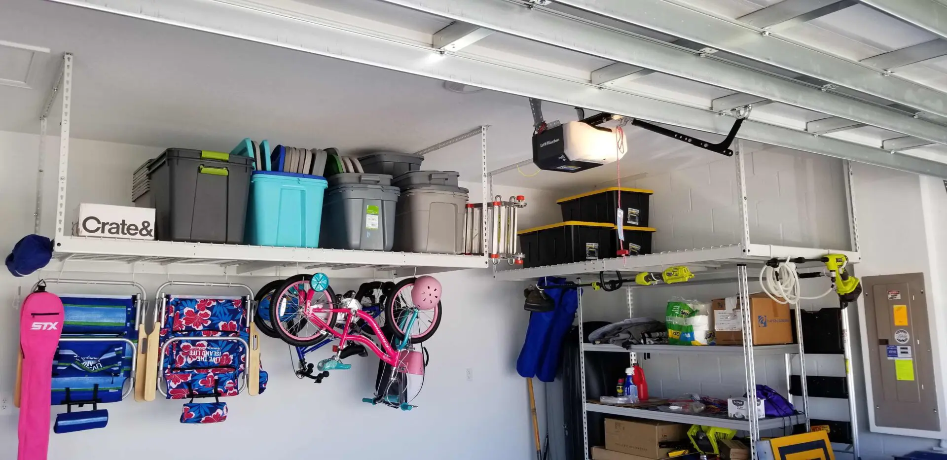Crates and foldable ladders on the overhead storage, bicycles and chairs on the hooks